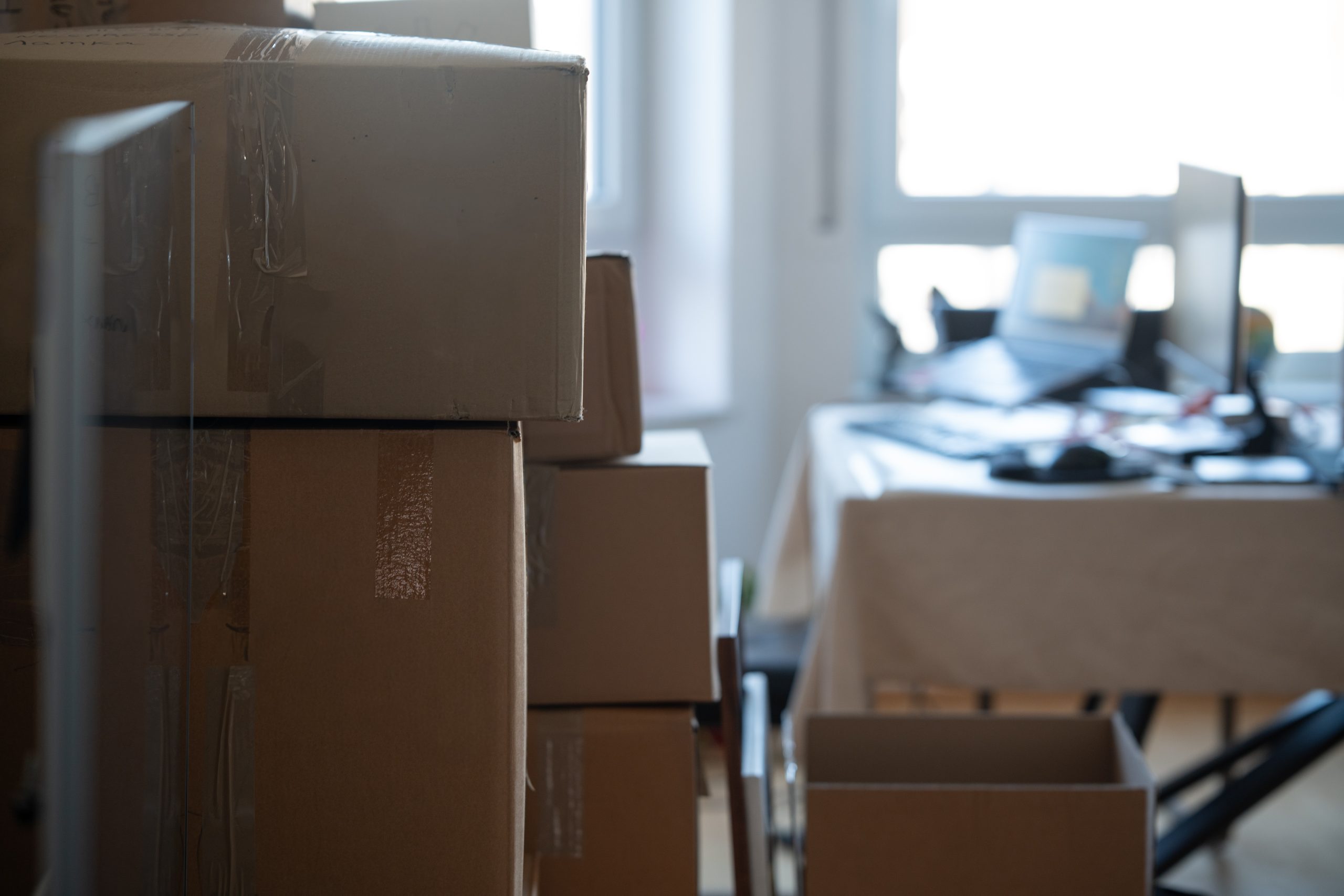 Stacked,Cardboard,Boxes,In,An,Office,Interior,With,Desk,And